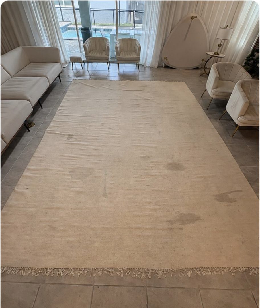 Large area rug with stains before cleaning